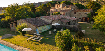 Ombrelloni, sedie a sdraio e lettini vicini
									alla piscina nel parco dell’antico Monastero San Silvestro